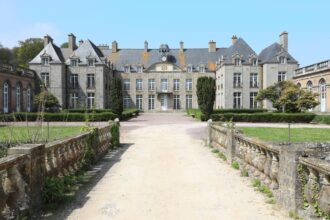 Vue d’un château français entouré de jardins, illustrant la tendance 2026 de la location de demeures historiques pour les vacances.