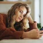 Personnes utilisant une application de rencontre sur smartphone, illustrant la transformation des sociabilités à l’ère numérique.