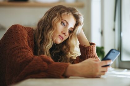 Personnes utilisant une application de rencontre sur smartphone, illustrant la transformation des sociabilités à l’ère numérique.