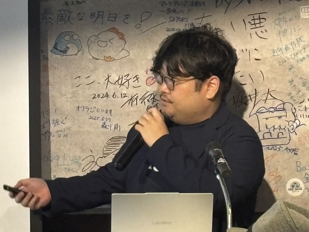 向山純平 présentant du saké japonais lors d’un événement culturel, mettant en valeur les brasseries artisanales et la tradition du brassage.