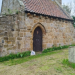 Vue de l’ancienne église Saint‑André d’Upleatham, entourée de collines et d’un cimetière ancien, symbole du mystère du village.