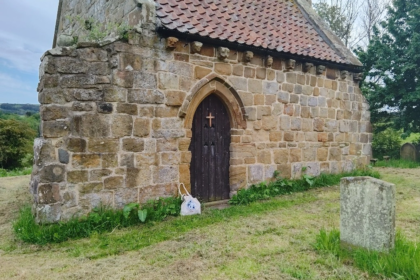 Vue de l’ancienne église Saint‑André d’Upleatham, entourée de collines et d’un cimetière ancien, symbole du mystère du village.