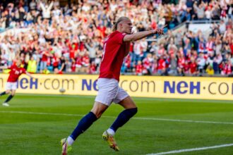 Erling Haaland célébrant l’un de ses deux buts face à l’Irak, illustrant la victoire de la Norvège et la puissance offensive de l’attaquant.