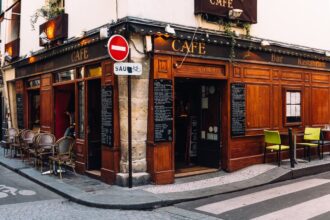 Un bistrot traditionnel français avec comptoir en zinc et terrasse vide, illustrant la disparition progressive de ces lieux de convivialité dans le paysage français.