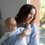 Portrait d’une mère seule avec son enfant dans un environnement urbain, illustrant la précarité croissante des familles monoparentales en France.
