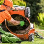 Atelier de maintenance de motoculture avec tondeuse, tronçonneuse et tracteur en cours de révision, illustrant l’entretien et la réparation de machines d’espaces verts.