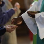 Prêtre étranger célébrant une messe dans une église française, symbole du renouveau pastoral.