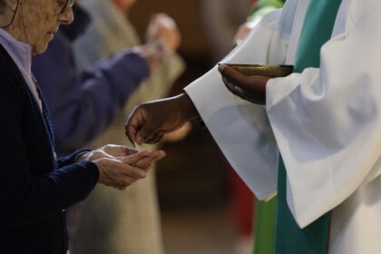 Prêtre étranger célébrant une messe dans une église française, symbole du renouveau pastoral.