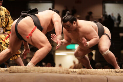 Lutteur de sumo dans le dohyō, accomplissant un rituel shinto ancestral, symbole de la tradition japonaise et de la spiritualité du sumo.