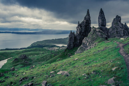 Vue atmosphérique de Thurso au crépuscule, avec les ruines d’Old St. Peter’s Kirk et la mer du Pentland Firth sous une lumière nordique brumeuse.