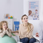 Parents aidant un enfant à faire ses devoirs, illustrant l’accompagnement familial du TDAH.