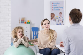 Parents aidant un enfant à faire ses devoirs, illustrant l’accompagnement familial du TDAH.