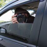 Détective privé analysant des documents et surveillant des activités professionnelles, illustrant les enquêtes internes, la lutte contre la fraude et la protection des données sensibles dans les entreprises.